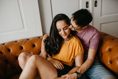 Young couple sitting on sofa at home