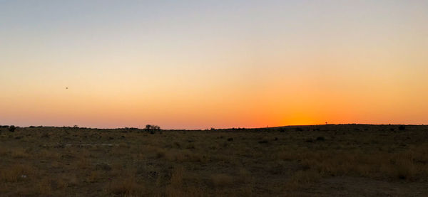 Silhouette landscape against clear sky during sunset