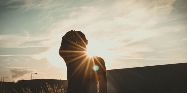 Silhouette woman standing against sky during sunset