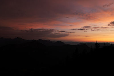 Scenic view of silhouette mountains against orange sky