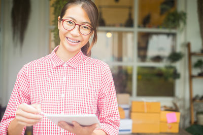 Portrait of smiling businesswoman holding digital tablet