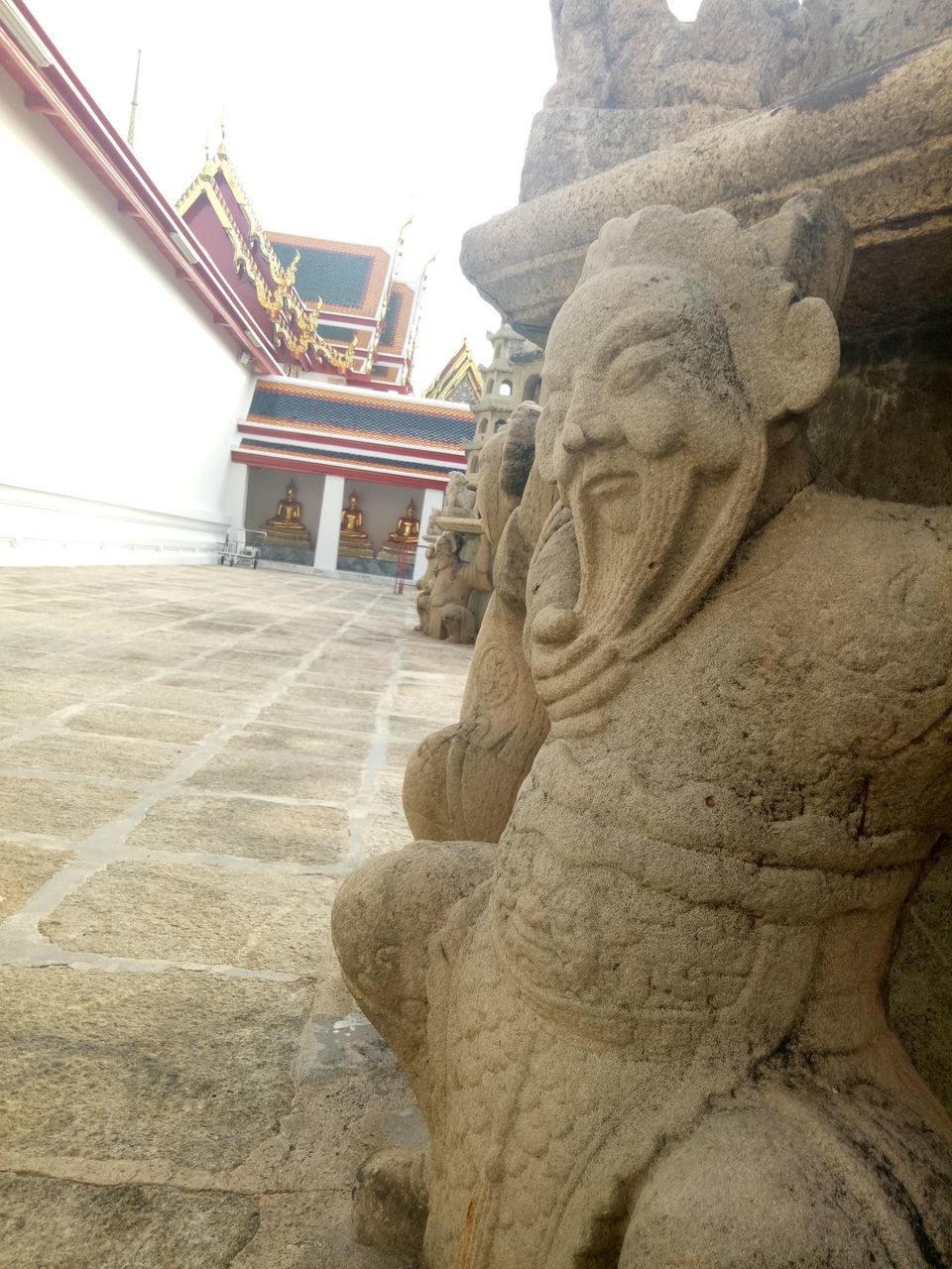 STATUE OF BUDDHA AGAINST BUILDING