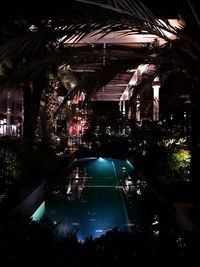 Aerial view of swimming pool by building at night