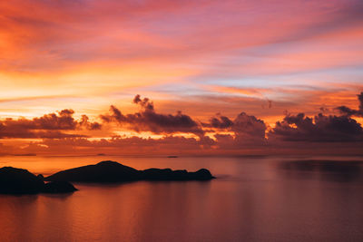 Scenic view of sea against dramatic sky during sunset