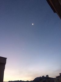 Low angle view of moon against clear blue sky