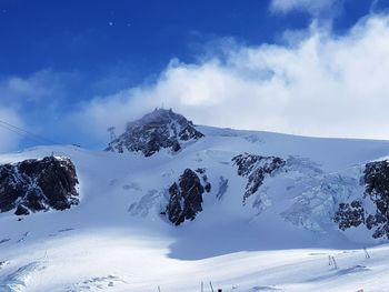 Scenic view of snowcapped mountain against blue sky