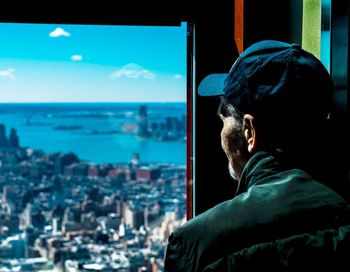 Rear view of man and cityscape against sky