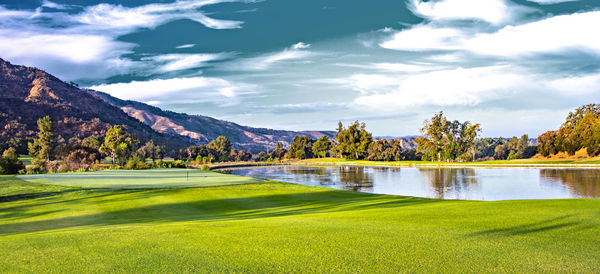 Scenic view of golf course against sky