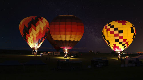 Multi colored hot air balloon flying in sky at night