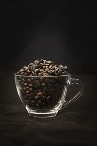 Close-up of coffee beans on table against black background