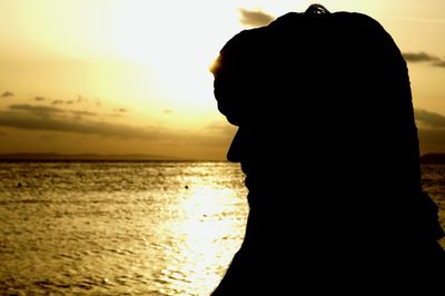 Silhouette of woman on beach at sunset