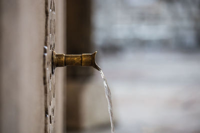 Close-up of water pipe on wood against wall
