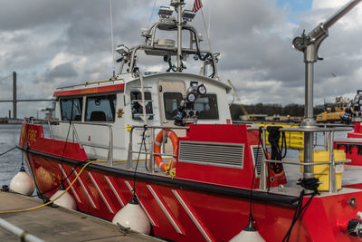 Fire and rescue boat moored in sea against sky