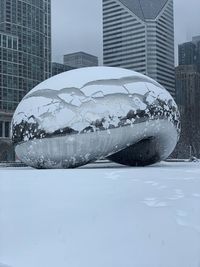 Snow covered buildings against sky in city