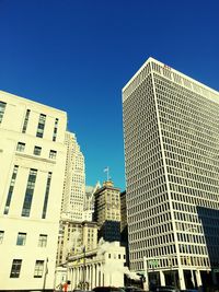 Low angle view of buildings against clear blue sky