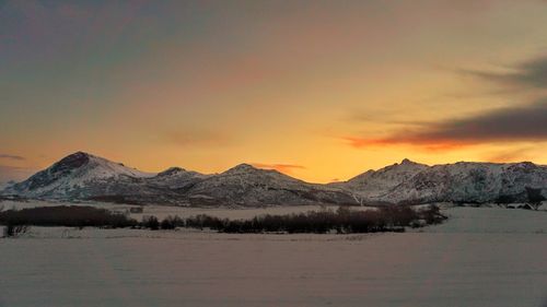 Scenic view of snowcapped mountains against sky during sunset