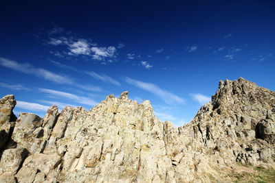 Low angle view of rocks against blue sky