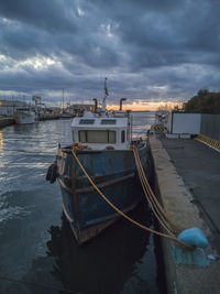 Boats moored at harbor against sky