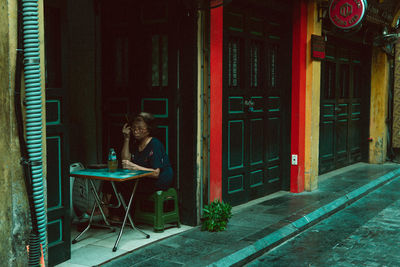 Rear view of woman sitting on street