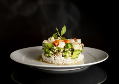 Close-up of food in plate against black background