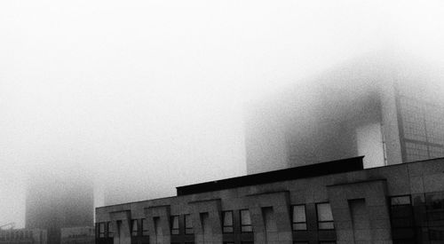 Low angle view of buildings in foggy weather