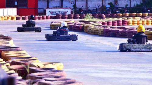 Rear view of people racing on go-carts