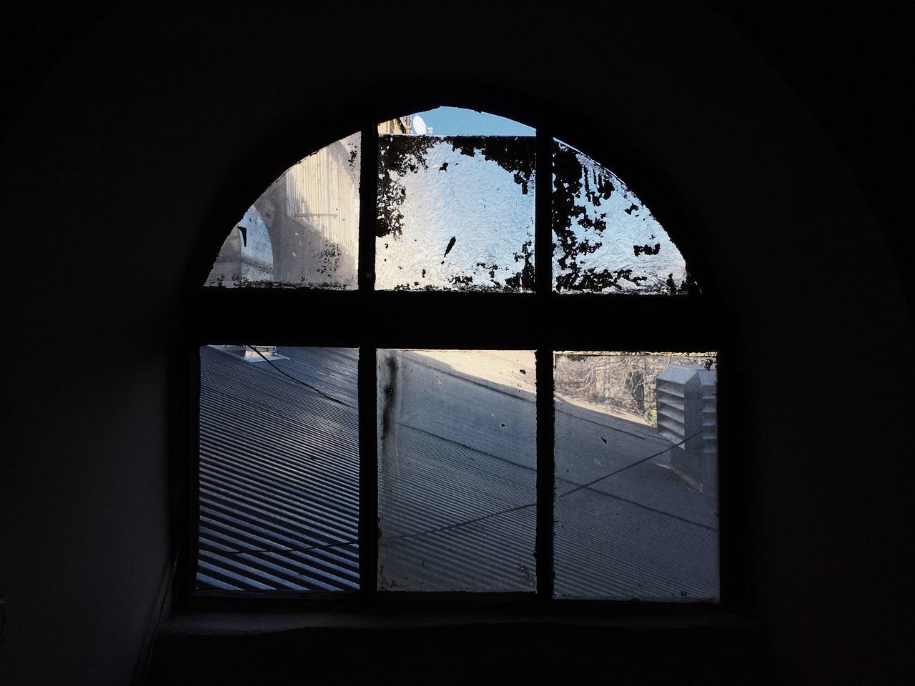 WINDOW OF BUILDING AGAINST SKY SEEN THROUGH ARCH