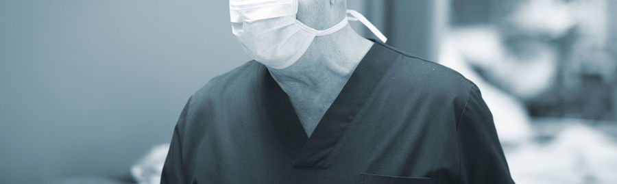 Midsection of senior man wearing surgical mask