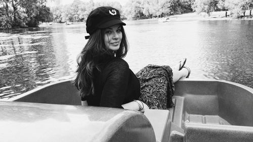 Portrait of smiling young woman sitting in lake