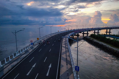 Bridge over road against sky during sunset