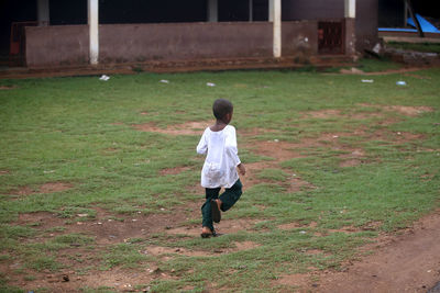 Rear view of man running on field