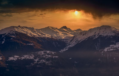 Scenic view of snowcapped mountains against sky during sunset