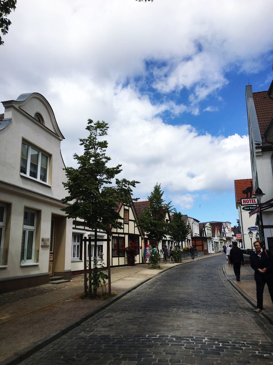 STREET BY BUILDINGS AGAINST SKY