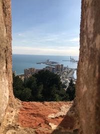 Cityscape by sea against sky