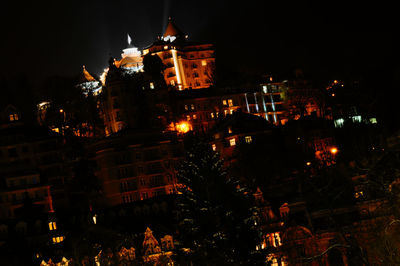 Low angle view of illuminated buildings in city at night