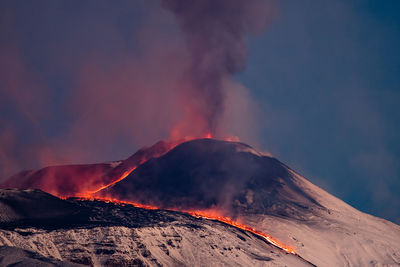 Smoke emitting from volcanic mountain against sky