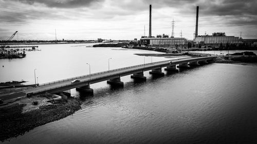 Bridge over river against sky in city