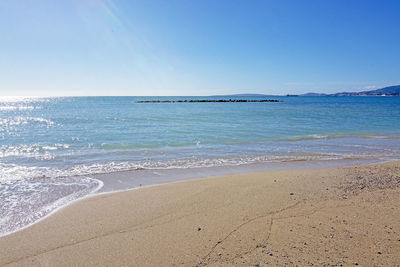 Scenic view of beach against blue sky