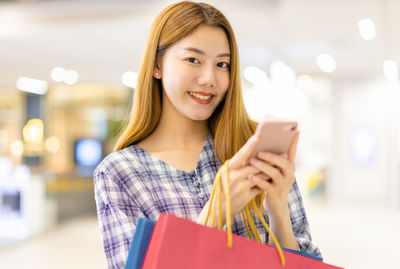 Portrait of happy young woman using mobile phone