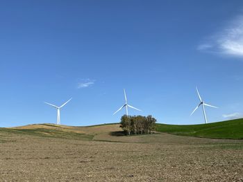 Windmill on field against sky