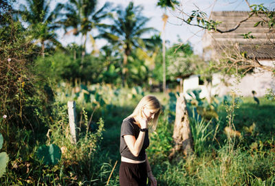 Full length of woman standing by plants