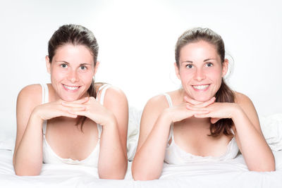 Portrait of a smiling young woman against white background