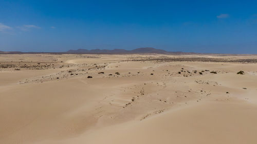 Scenic view of desert against blue sky