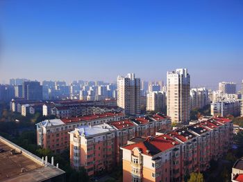 High angle view of buildings against blue sky