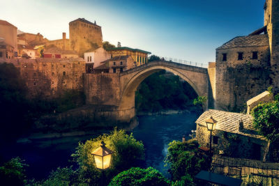 Arch bridge over river against sky