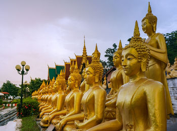 Statue against temple and building against sky