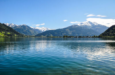 Scenic view of lake and mountains against blue sky