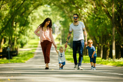 Full length of family walking on road