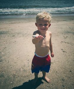 Portrait of happy boy standing on beach