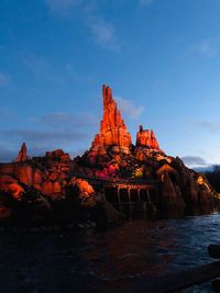 Rock formation in water against sky